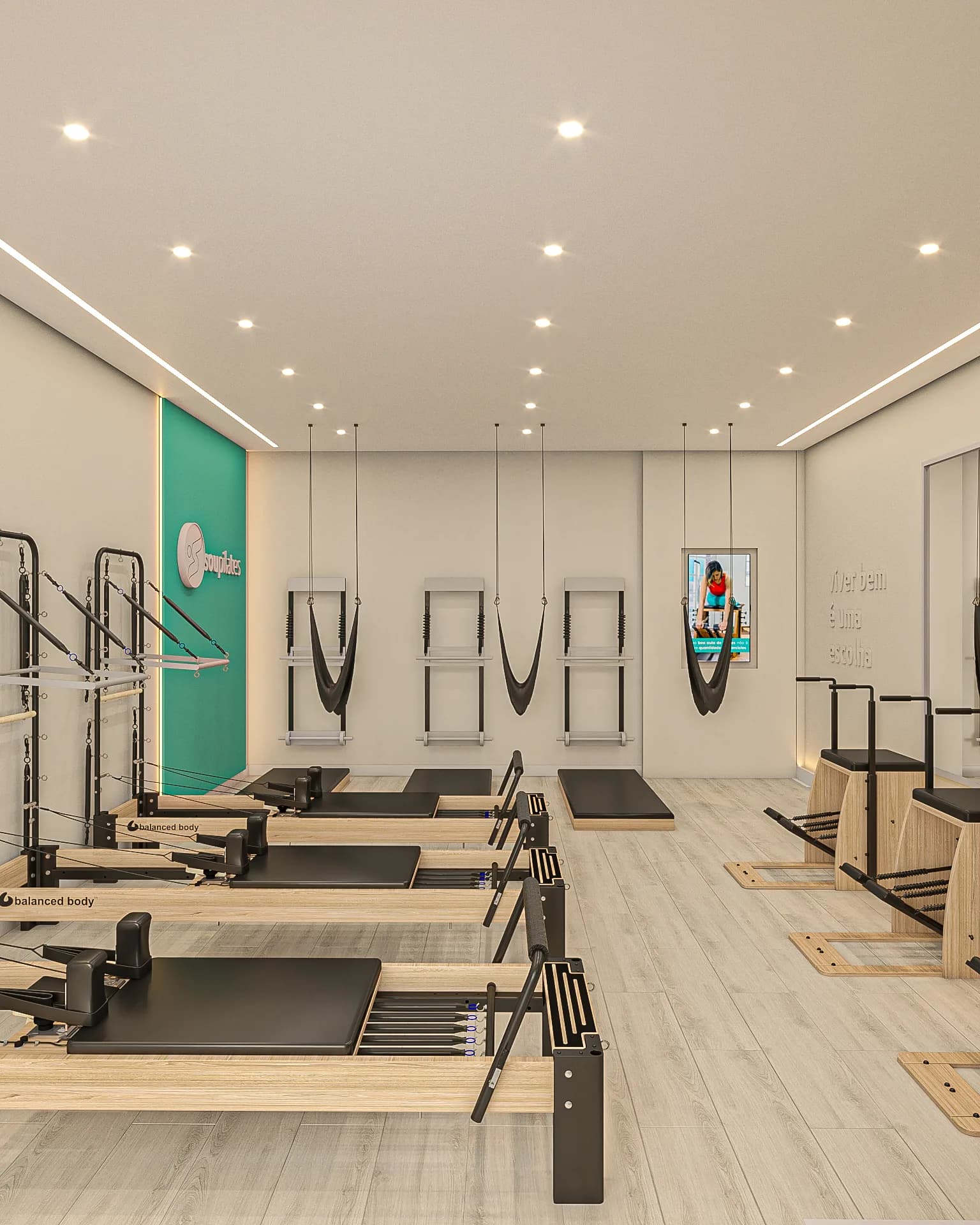 Sala de pilates da Sou Pilates com reformers, cadillac e parede de marca em verde.