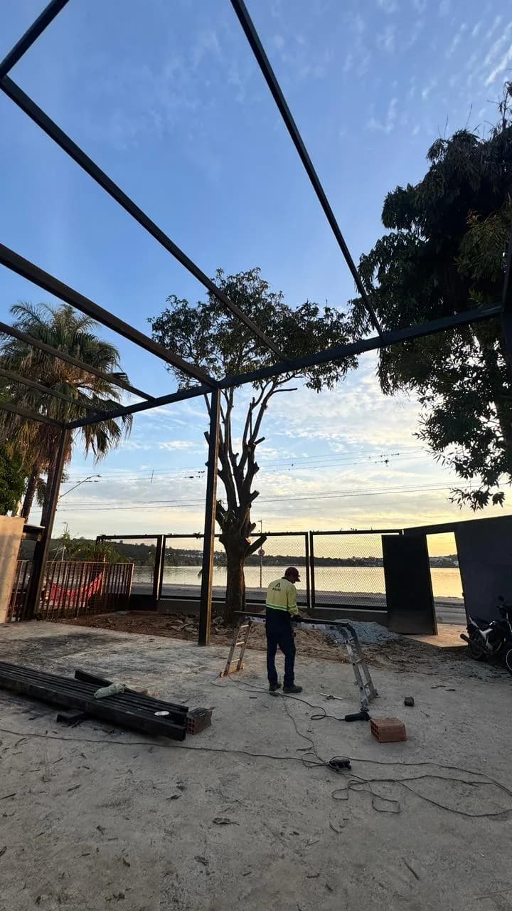 Antes da Altimetria: vista para a rua através da estrutura metálica do telhado, com vigas no chão e um operário.